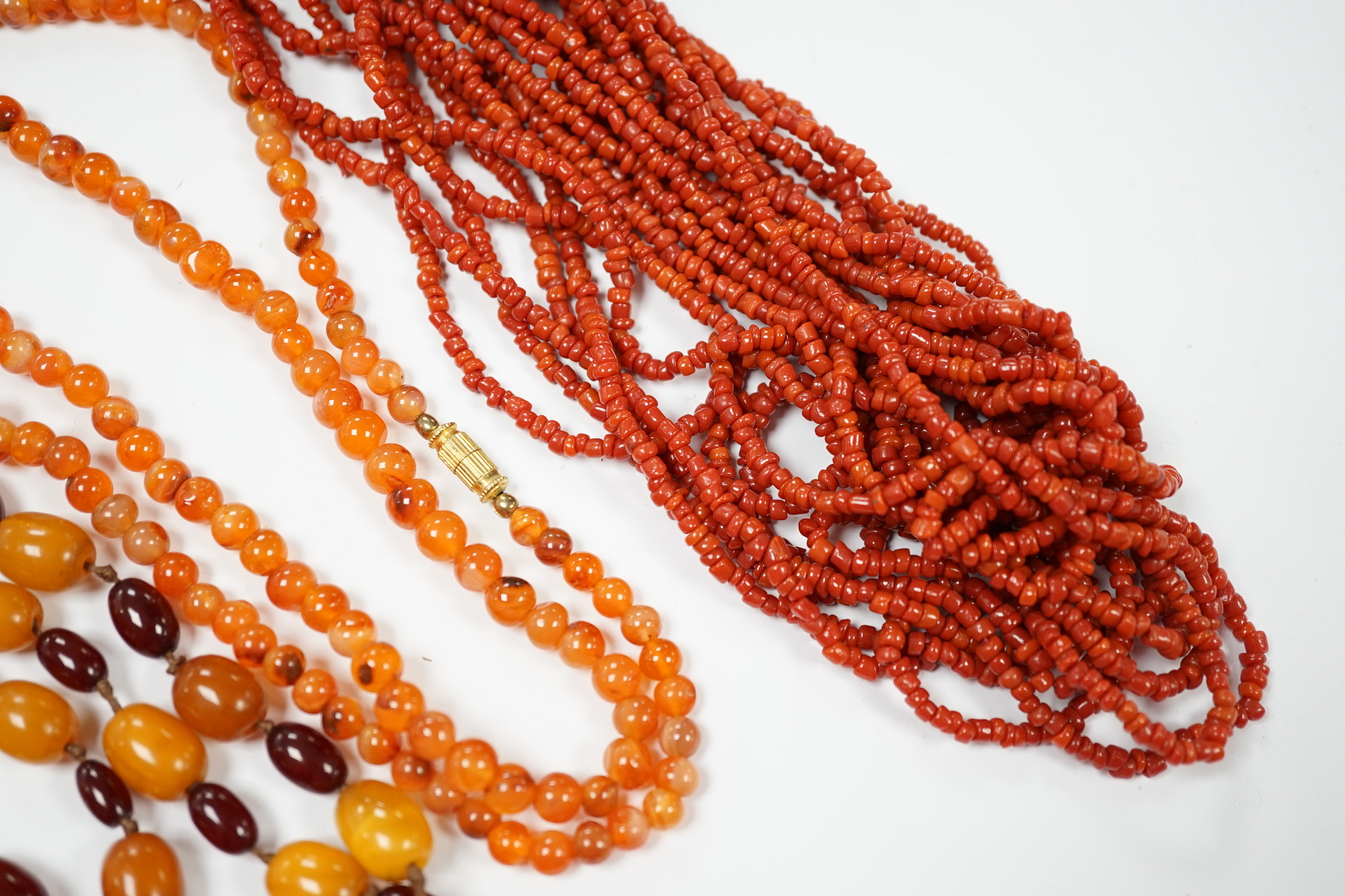 A single strand amber and simulated cherry amber bead necklace, 72cm, gross weight 33 grams, together with two other necklaces including agate bead.